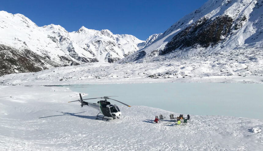 Helicopter parked up by a frozen glacier lake