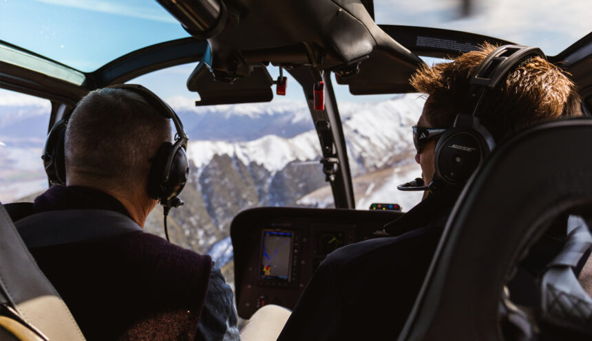 Pilot and passenger flying in a helicopter through the southern alps